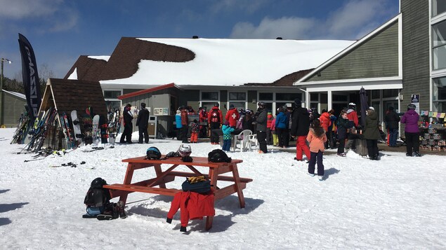 Des skieurs devant le chalet du Mont-Édouard.