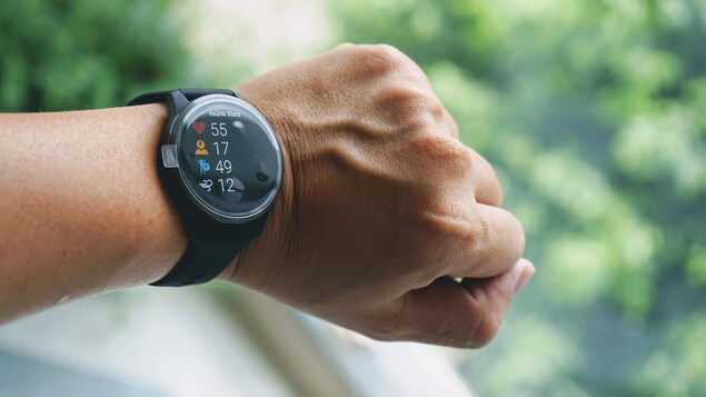 Une montre connectée Garmin sur le poignet d'une personne, en gros plan.