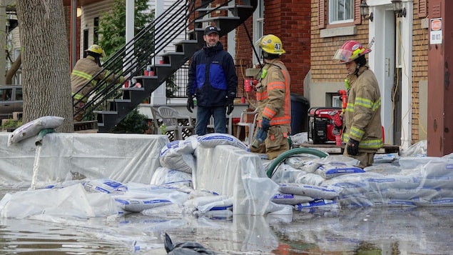 Des pompiers aident des sinistrés à Montréal.