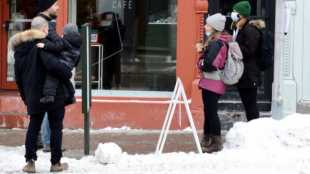 Deux couples avec un enfant près d’un café à Montréal.