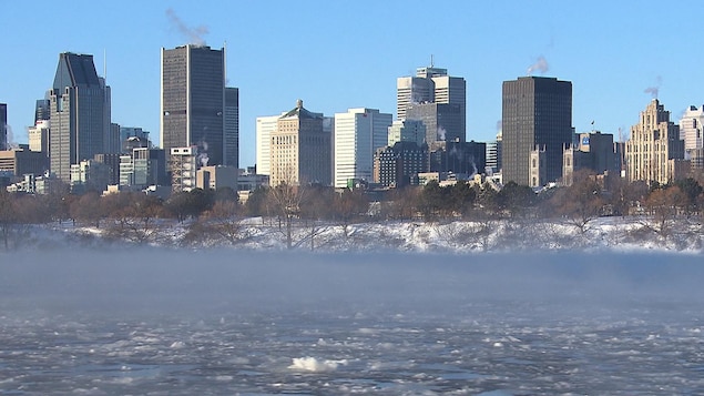 De la fumée s'échappe du fleuve Saint-Laurent avec des immeubles montréalais en arrière-plan.