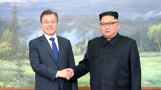 Les deux hommes se tiennent côte-à-côte, Moon Jae-in à gauche, et Kim Jong-un à droite. Les deux hommes se tiennent côte-à-côte, Moon Jae-in à gauche, et Kim Jong-un à droite.