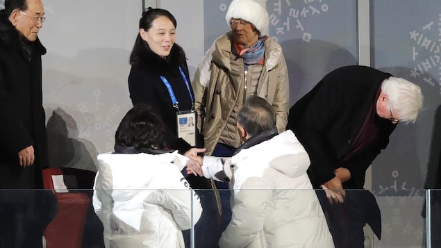 Moon Jae-in serre le main de Kim Yo-jong dans les gradins du stade où se déroule la cérémonie d'ouverture.