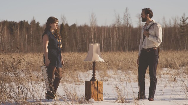 Une photo du duo Moonfruits, composé de Kaitlin Milroy et Alex Millaire, dans une clairière sur un sol enneigé Une photo du duo Moonfruits, composé de Kaitlin Milroy et Alex Millaire, dans une clairière sur un sol enneigé