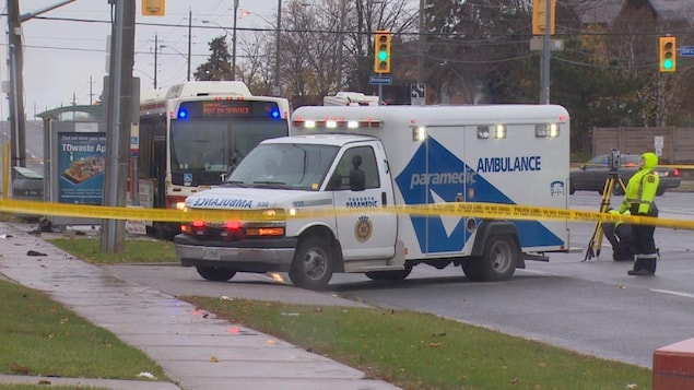 Photo d'une banderole de police jaune devant une ambulance et un autobus de la CTT Photo d'une banderole de police jaune devant une ambulance et un autobus de la CTT
