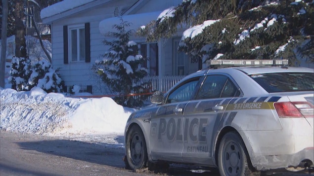 Une voiture de la police de Gatineau devant un logement autour duquel il y a un cordon de sécurité.