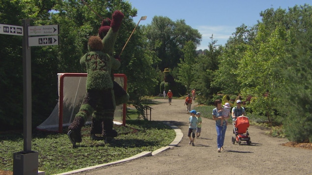 Des marcheurs sur un sentier qui admirent des sculptures horticoles. Des marcheurs sur un sentier qui admirent des sculptures horticoles.