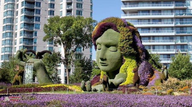 Le visage d'une femme, les yeux fermés, avec des cheveux en fleur. L'oeuvre est constituée entièrement de végétation. 
