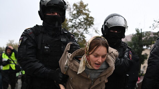 Des policiers arrêtent une manifestante à Moscou.
