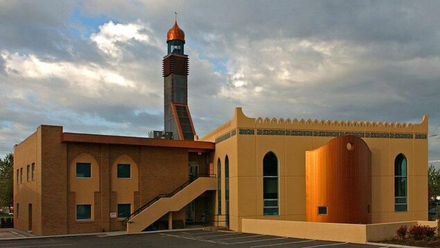 La mosquée est dans le style orientale, de couleur jaune, surmplobée d'un minaret