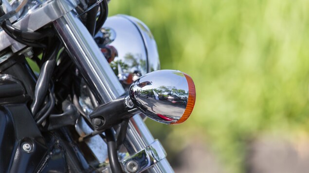 Plan rapproché des pièces chromées d'une moto immobilisée.
