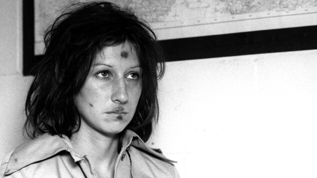 Scène du film Mourir à tue-tête, d'Anne Claire Poirier, avec l'actrice Julie Vincent qu'on voit en gros plan et en noir et blanc, le regard triste et le visage meurtri de plaies. Scène du film Mourir à tue-tête, d'Anne Claire Poirier, avec l'actrice Julie Vincent qu'on voit en gros plan et en noir et blanc, le regard triste et le visage meurtri de plaies.