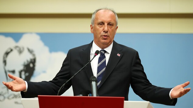 Muharrem Ince se tient les bras ouverts devant un micro. Muharrem Ince se tient les bras ouverts devant un micro.