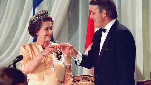 Le premier ministre et la reine portent un toast.