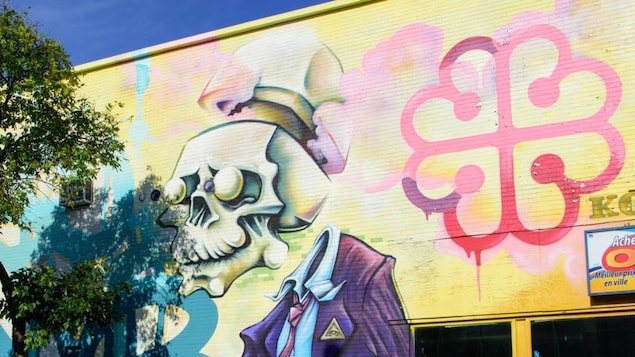 Graffiti montrant un squelette en complet et un logo de la Ville de Montréal.