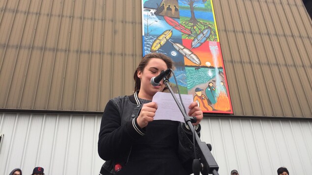 Une étudiante devant une murale. Une étudiante devant une murale.