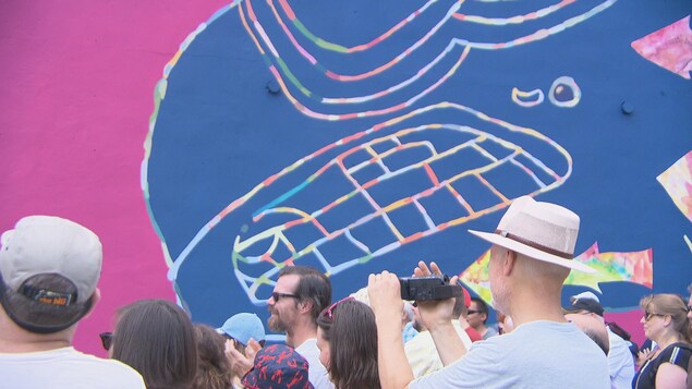 Des gens devant une murale Des gens devant une murale