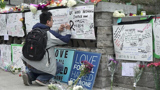 Photo d'un homme qui écrit un message sur un carton. Photo d'un homme qui écrit un message sur un carton.