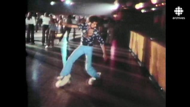 Un jeune homme danse sur de la musique disco en patin à roulettes.