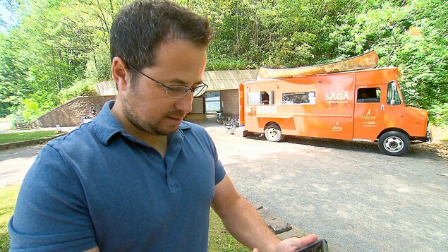 Nagib El Mansouri, porte-parole de l'application Camarad, en train de consulter son téléphone près d'un camion de cuisine de rue Nagib El Mansouri, porte-parole de l'application Camarad, en train de consulter son téléphone près d'un camion de cuisine de rue