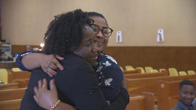 Nancie Auguste et Slina Saint-Juste se serrent dans leurs bras à la paroisse St-Jean-Baptiste, à Regina