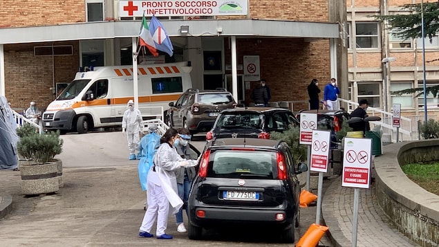 Des travailleurs de la santé près d'une voiture.