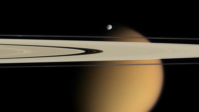 Photo captée par la sonde Cassini montrant les anneaux de Saturne, avec en arrière-plan la lune Titan. On aperçoit également la petite lune Épiméthée. Photo captée par la sonde Cassini montrant les anneaux de Saturne, avec en arrière-plan la lune Titan. On aperçoit également la petite lune Épiméthée.