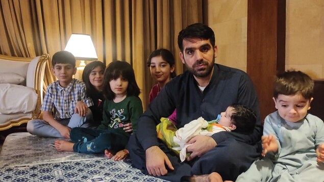 Mohammad Nasimi and his children pose in the hotel room in Islamabad where they're staying, until they can move to Canada. (Mohammad Nasimi )