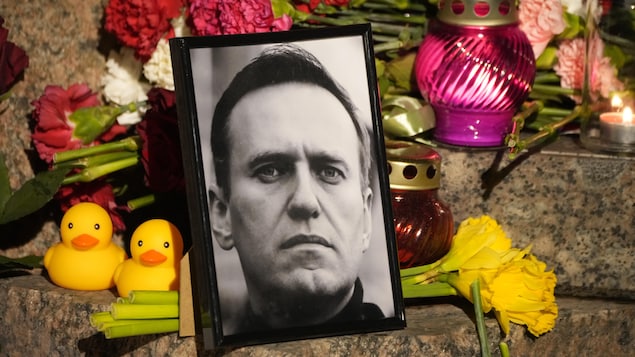 A portrait of Russian opposition leader Alexei Navalny, flowers and candles are laid on a ground as people gather to pay their last respect to Alexei Navalny at the Memorial to Victims of Political Repression in St. Petersburg, Russia on Friday, Feb. 16, 2024. Russian authorities say that Alexei Navalny, the fiercest foe of Russian President Vladimir Putin who crusaded against official corruption and staged massive anti-Kremlin protests, died in prison. He was 47. (AP Photo/Dmitri Lovetsky)