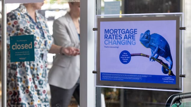 Isang sign sa pintuan na gawa sa glass na nagsasabing 'mortgage rates are changing.'
