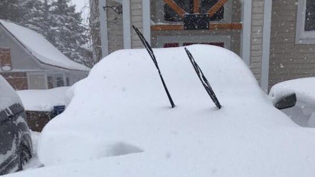 Une voiture ensevelie sous la neige.