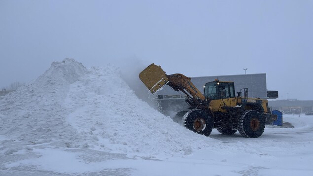 Une déneigeuse déblaie le stationnement de Place de Ville, à Sept-Îles.