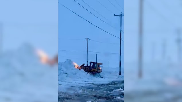 Un tracteur en train de déneiger, à Puvirnituq.