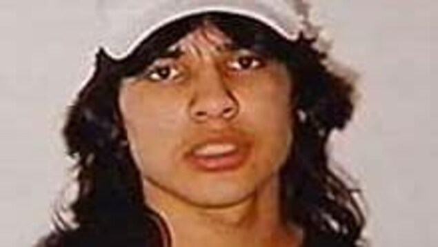 Portrait de Neil Stonechild, cheveux longs et casquette sur la tête.