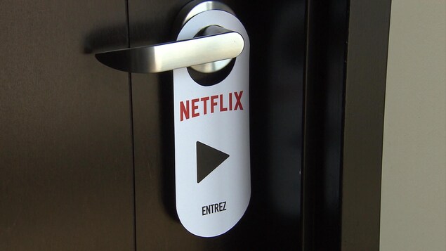 Un carton de Netflix est accroché sur une poignée de porte. Un carton de Netflix est accroché sur une poignée de porte.