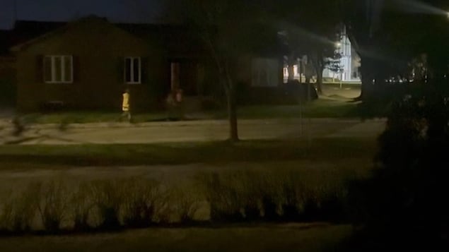 Deux personnes sur le trottoir la nuit.