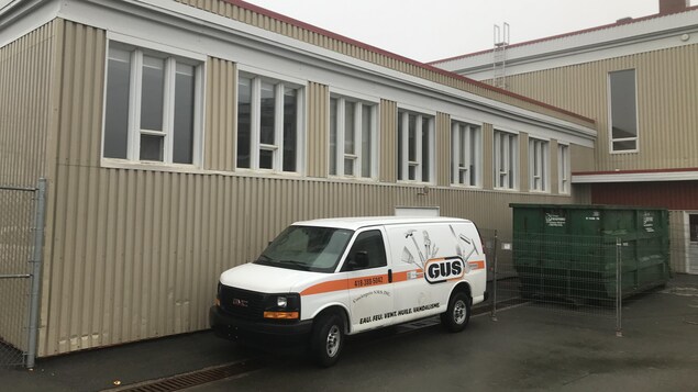 Une camionnette d'une compagnie de nettoyage est stationnée devant l'école New Carlisle High School.