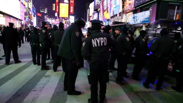 La police new-yorkaise surveille attentivement la foule qui se masse à Times Square. La police new-yorkaise surveille attentivement la foule qui se masse à Times Square.