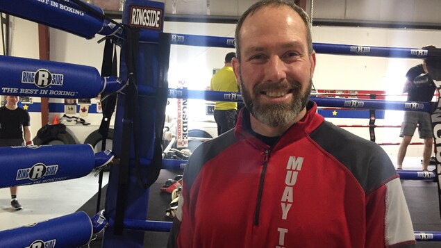 L'entraîneur pose devant le ring. L'entraîneur pose devant le ring.