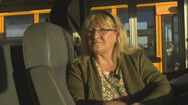 Nicole Couture assise sur le siège du conducteur dans un autobus scolaire