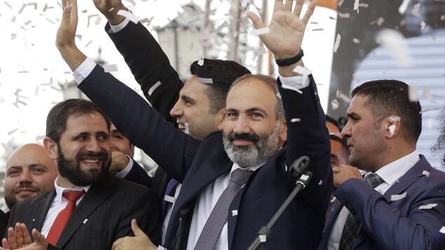 Nikol Pachinian, entouré de quelques proches, lève les bras dans les airs en signe de victoire.