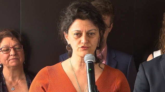 Elle parle dans un micro.