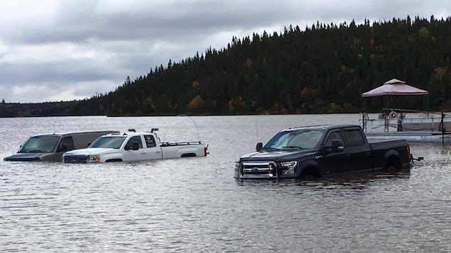 Des camions inondés par la montée du niveau de l'eau d'un lac de l'Abitibi.