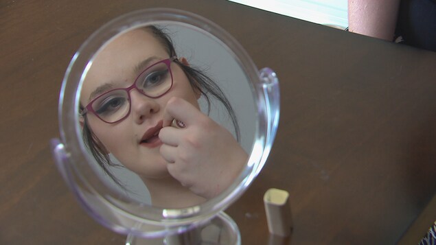Une adolescente transgenre de 16 ans se maquille devant un miroir Une adolescente transgenre de 16 ans se maquille devant un miroir