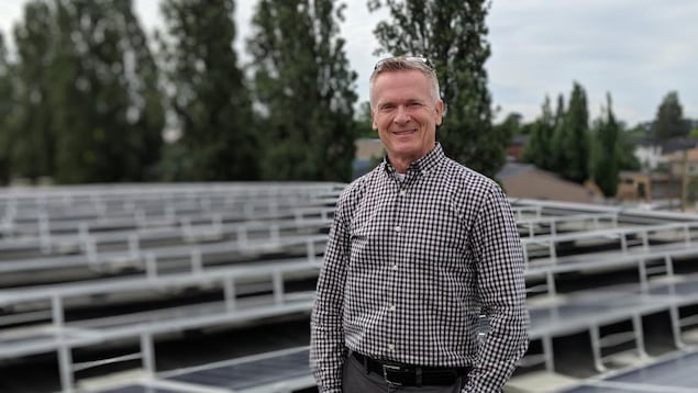 Un homme debout devant des panneaux solaires. Un homme debout devant des panneaux solaires.