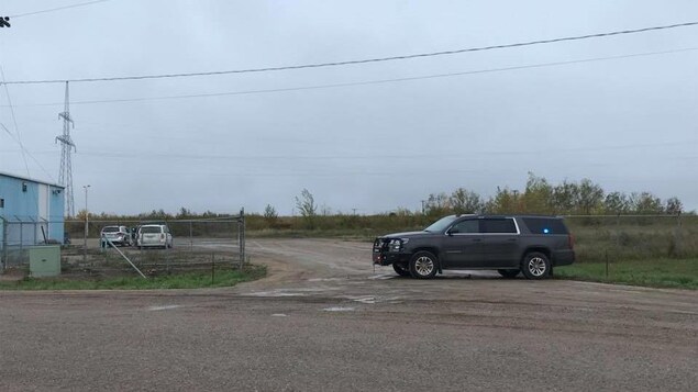 Une voiture de police est garée devant l'entrée d'un chantier industriel. Une voiture de police est garée devant l'entrée d'un chantier industriel.