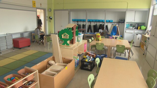 Une salle de classe avec des tables, des jouets éducatifs, des tapis de sol