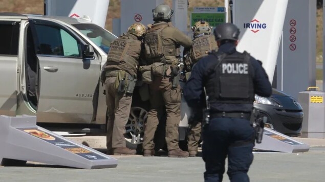 RCMP officers prepare to take a person into custody at a gas station in Enfield, N.S. on Sunday April 19, 2020. The gunman who killed 22 people was fatally shot by police at the gas station. (Tim Krochak/The Canadian Press)
