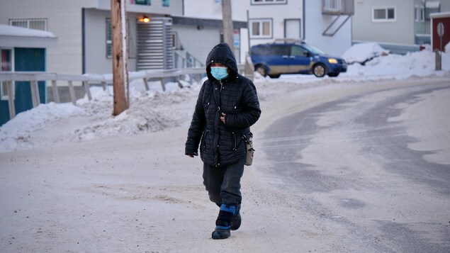 Une passante porte un masque dans une rue d'Iqaluit.