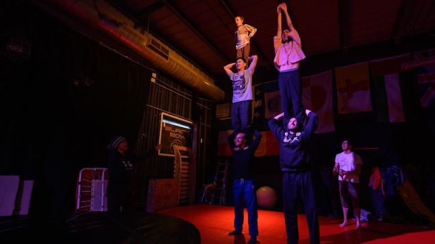 Cinq personnes sont en équilibre durant une répétition d'un spectacle de cirque, à Igloolik, au Nunavut. 